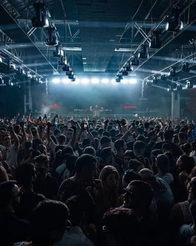 An audience watching a live show under blue lights