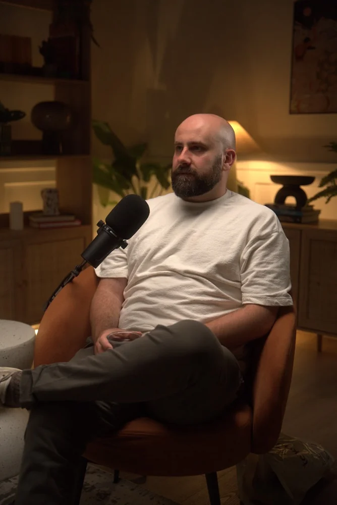 Alex Jobling seated at a podcast microphone