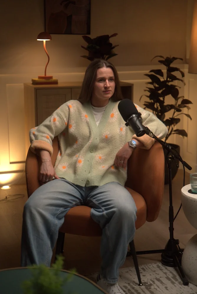 Maddy Raven seated at a podcast microphone