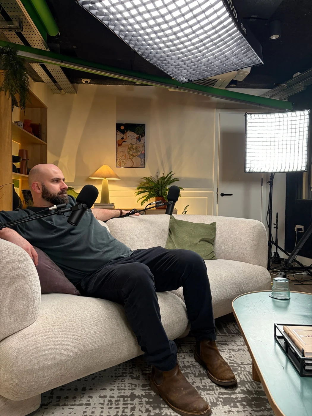 Alex seated for a recording with lights and microphone