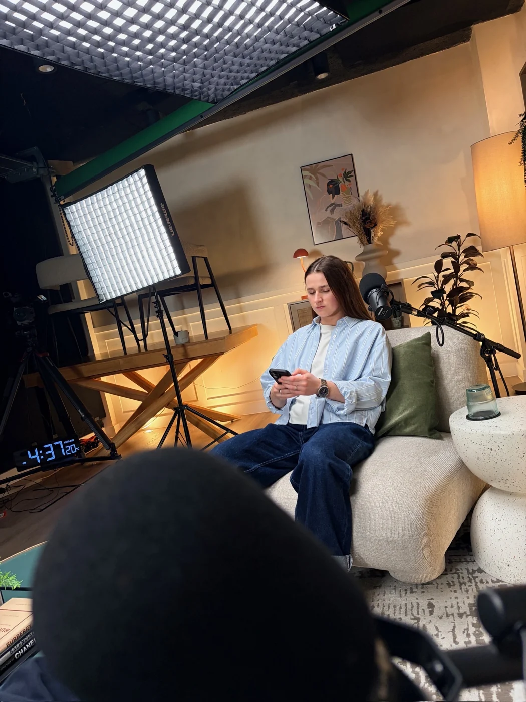 Maddy seated for a recording with lights and microphone