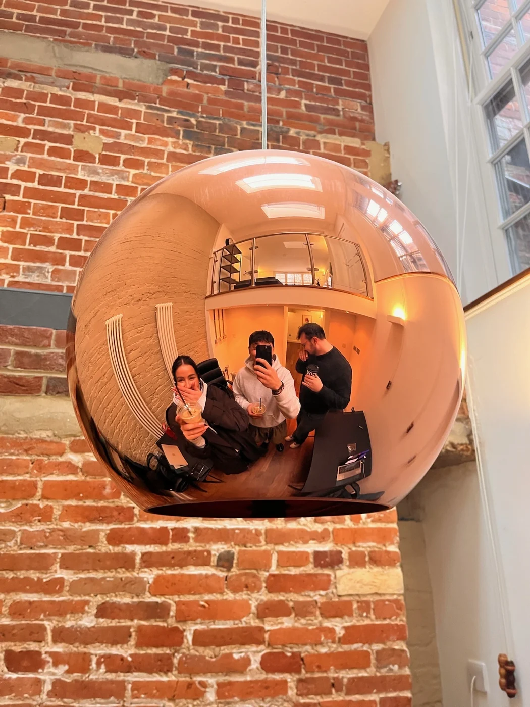 The team reflected in an office light fitting
