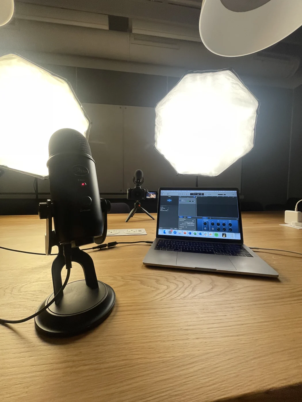 A recording setup with microphone, laptop and studio lighting