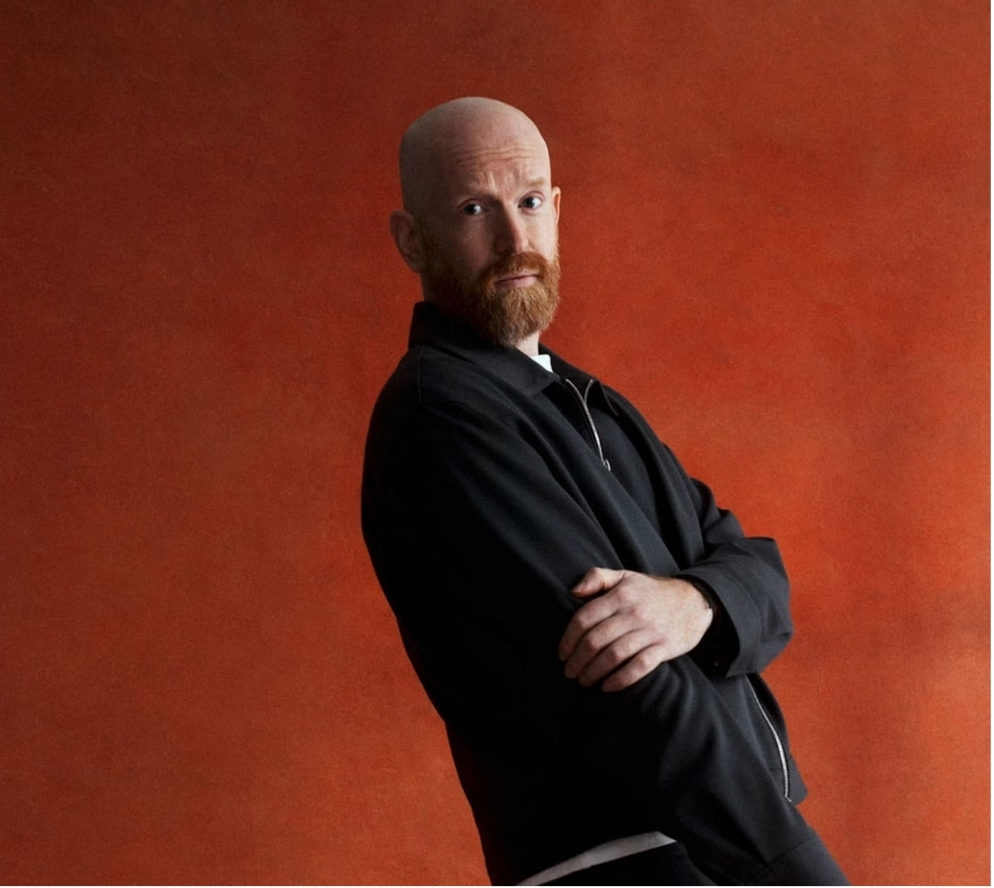 Artist portrait against an orange background